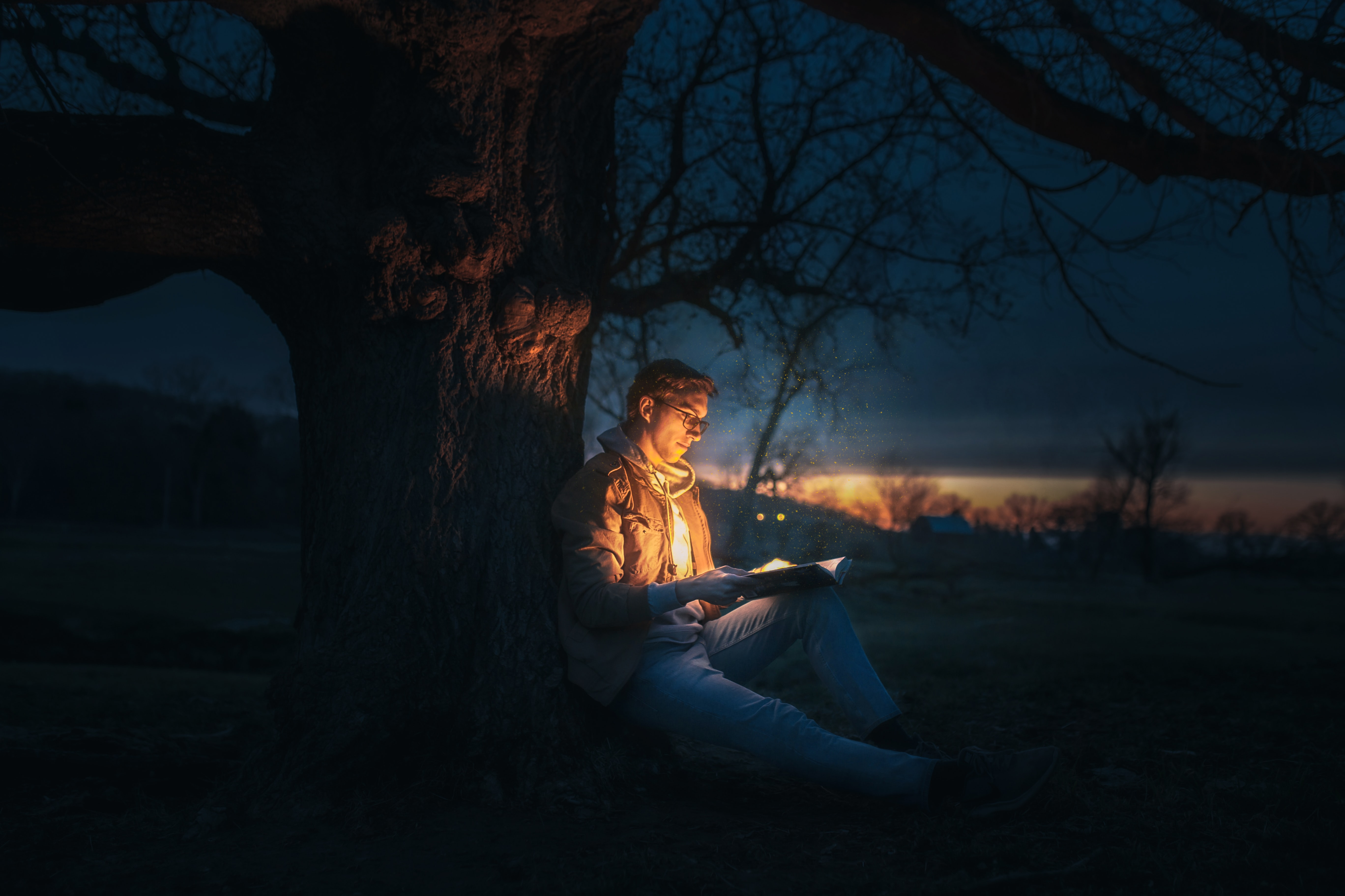 open book with lights, man reading in dark