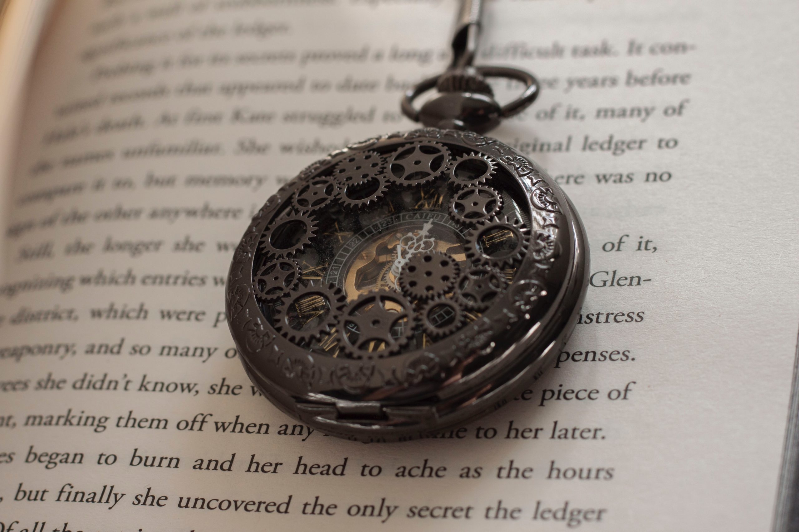 filigreed pocket-watch over words on page; typeset
